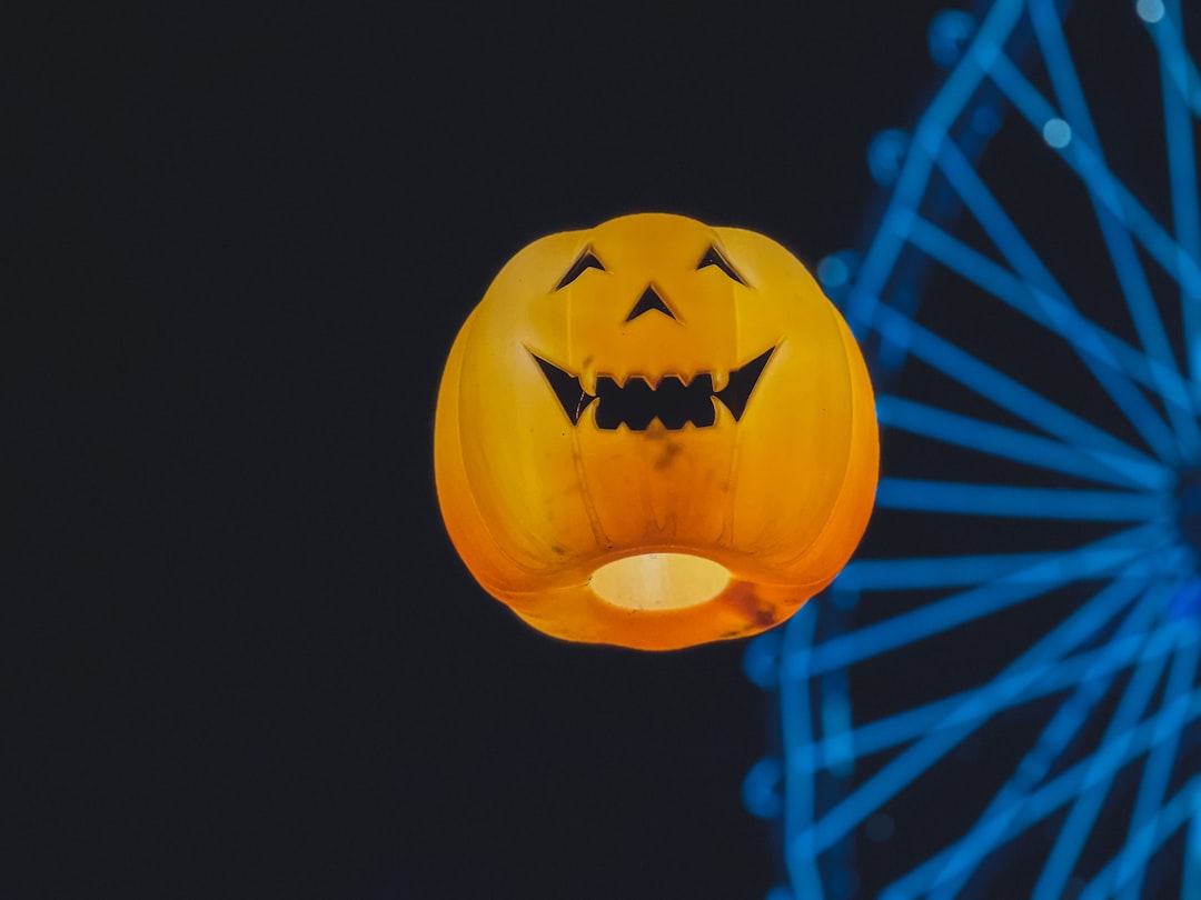 a close up of a pumpkin with a ferris wheel in the background