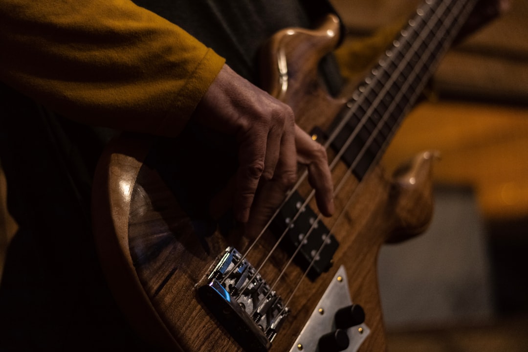 person in yellow shirt playing brown electric guitar