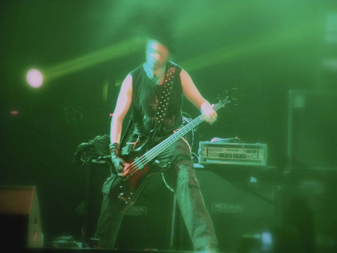 a man playing a bass guitar on stage